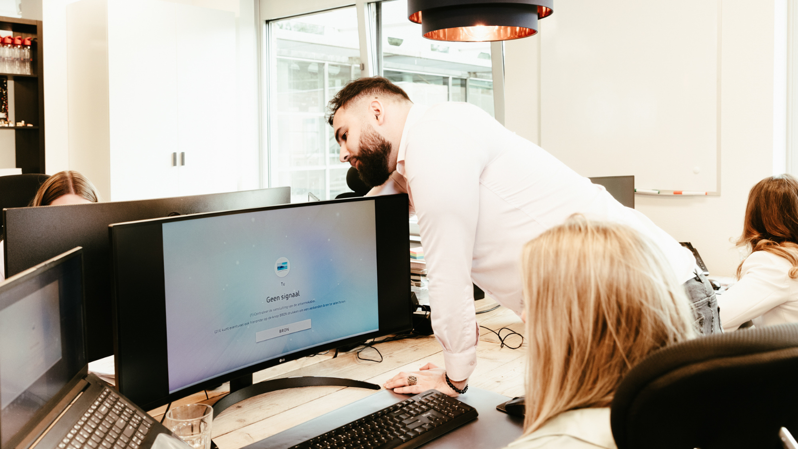 Systeembeheerder die gebruiker help met IT bij een detacheringsbureau